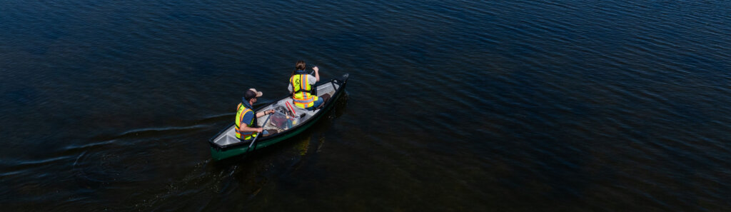 Two staff members paddling a canoe across Laddie Lake.