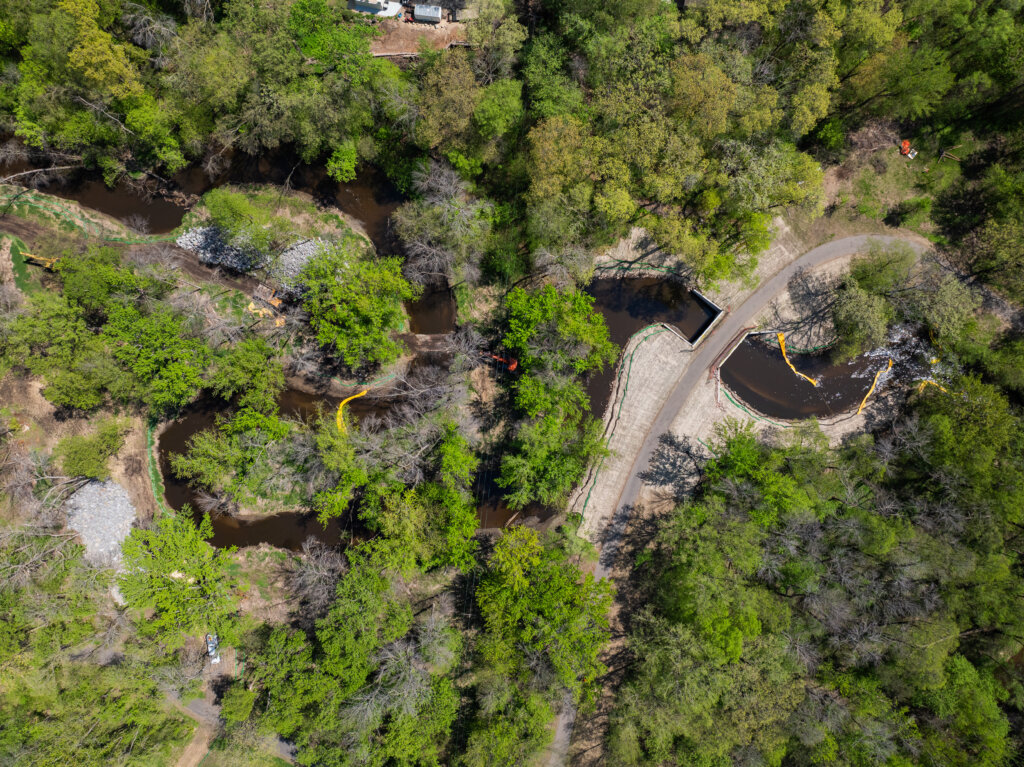 Aerial photo of Lower Coon Creek Corridor Restoration Site. Floating silt fence, bank stabilization, and newly replaced footbridge are visible. 